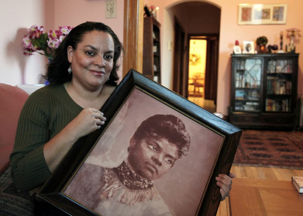 In this Dec. 2, 2011 file photo, Michelle Duster, great-granddaughter of civil rights pioneer Ida B. Wells who led a crusade against lynching during the early 20th century, holds a portrait of Wells in her home in Chicago's South Side. (Charles Rex Arbogast/AP)