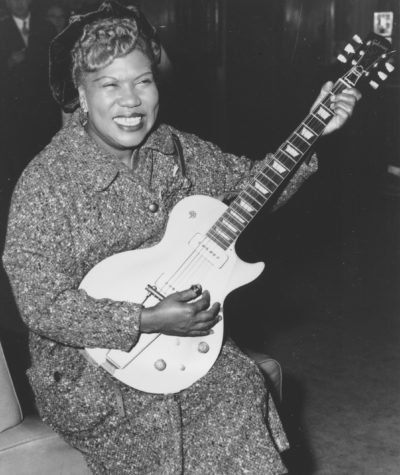 In this Nov. 21, 1957 photo, Sister Rosetta Tharpe, guitar-playing American gospel singer, gives an inpromptu performance in a lounge at London Airport. (AP)