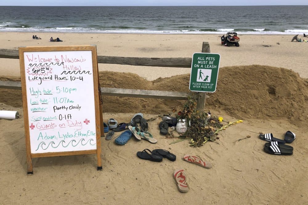 A sign informs visitors of lifeguard hours at Newcomb Hollow Beach in Wellfleet, Mass. Arthur Medici of Revere, Mass., died after being bitten by a shark offshore there on Sept. 15, 2018. (Susan Haigh/AP)