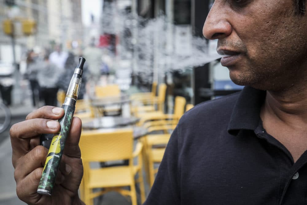 Inam Rehman, manager of Jubilee Vape & Smoke Inc., vapes while discussing New York Gov. Andrew Cuomo's push to enact a statewide ban on the sale of flavored e-cigarettes amid growing health concerns, Monday Sept. 16, 2019, in New York. (Bebeto Matthews/AP)