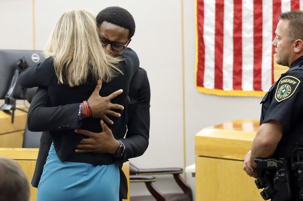 Botham Jean's younger brother Brandt Jean hugs convicted murderer and former Dallas Police Officer Amber Guyger after delivering his impact statement to her after she was sentenced to 10 years in jail, Wednesday, Oct. 2, 2019, in Dallas. (Tom Fox/The Dallas Morning News via AP, Pool)