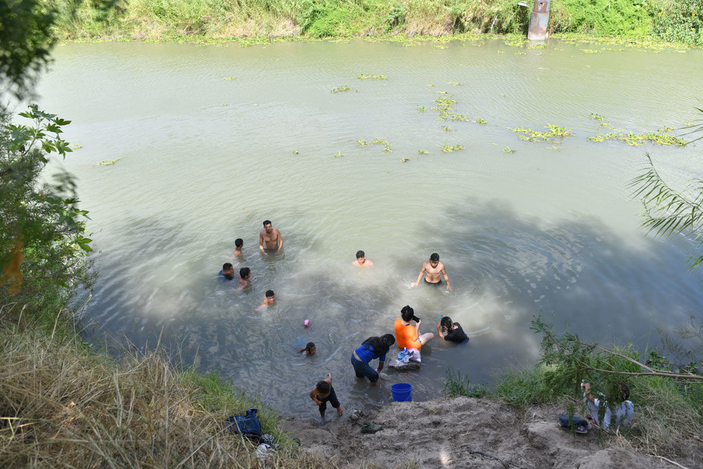Camp residents washing in the murky waters of the Rio Grande (Credit Paul Goyette)