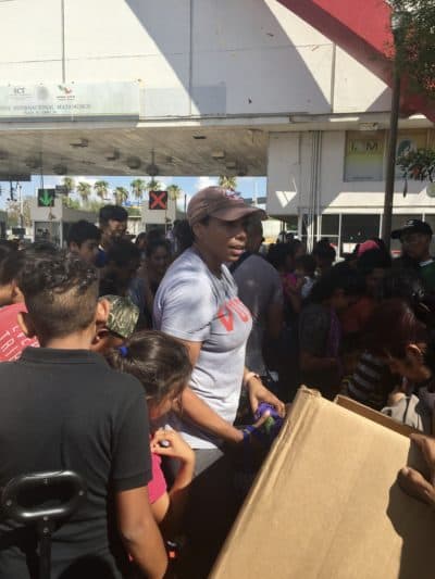 Felicia Rangel-Samponaro hands out relief supplies to asylum-seekers living in the Matamoros border encampment. (Yasmin Amer/WBUR)