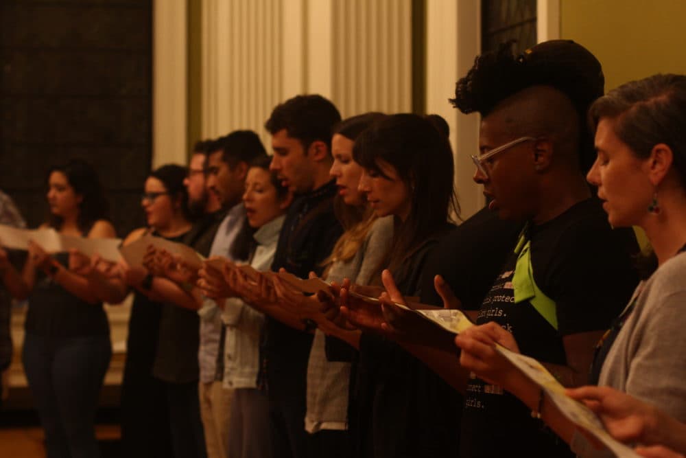 The audience looks at a scroll. It’s hand-illustrated and 170 feet long and 3 inches wide. Developed over 15 months as an artistic response to the devastation of Hurricane Maria, the illustrations tell the story of struggle and resistance to U.S. colonialism in Puerto Rico and its diaspora. (Courtesy Emilio Guillermo)