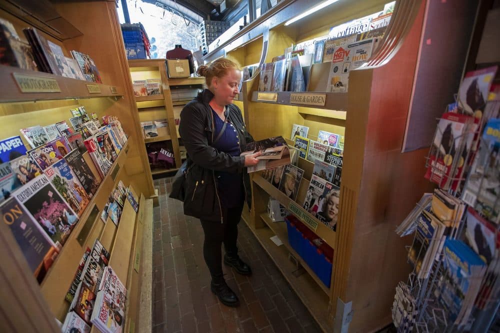 Diana Feik flips through the Halloween edition of Better Homes and Gardens at Out of Town News. (Jesse Costs/WBUR)
