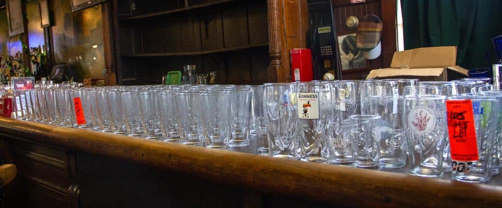 Dozens of beer glasses were for sale at the now-closed Doyle's pub in Jamaica Plain. The glasses were part of an auction that saw almost everything at the restaurant up for sale. (Meghan B. Kelly/WBUR)