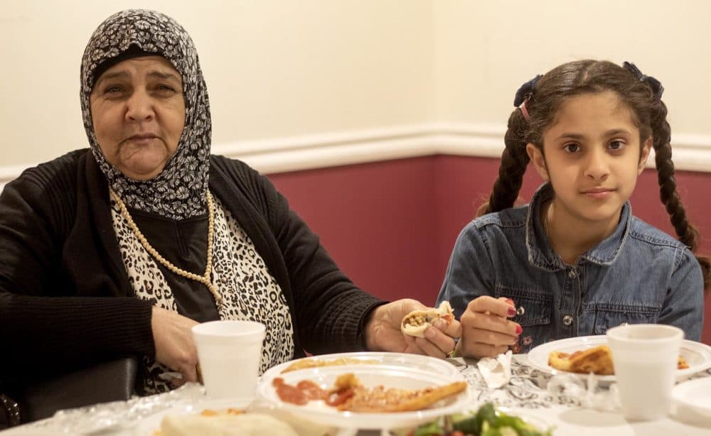 Fawza Aljamous and her granddaughter Toka Alasmi at a thanksgiving meal at the Hibernian Cultural Centre in Worcester. (Quincy Walters/WBUR)