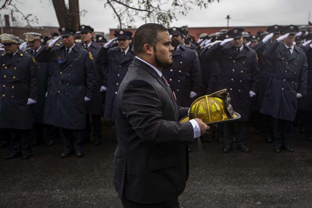 The helmet of fallen Worcester firefighter Lt. Jason Menard is carried during the procession to St. John’s Catholic Church. (Jesse Costa/WBUR)