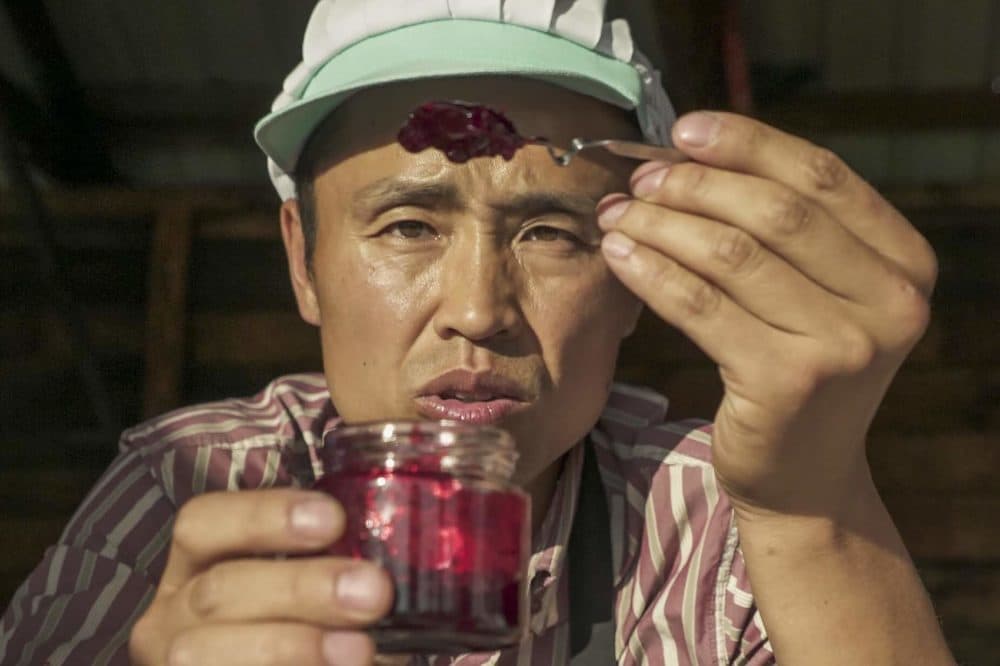 Jin Peng, owner of artisanal food company Willow's, checks his sauce. (Mengyu Zheng for WBUR)