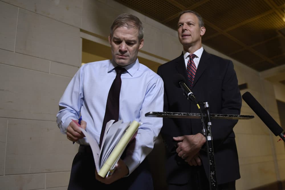 Rep. Jim Jordan, R-Ohio, left, looks for something in his notes as he and, Rep. Scott Perry, R-Pa., right, speak to reporters on Capitol Hill in Washington on Nov. 6 near the area where the interviews for the impeachment inquiry are being held. (Susan Walsh/AP)