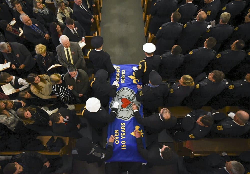 Pall bearers carry the casket of Worcester firefighter Lt. Jason Menard into his funeral mass in St. John's Church in Worcester, Mass. (Ashley Green/The Telegram & Gazette via AP, Pool)