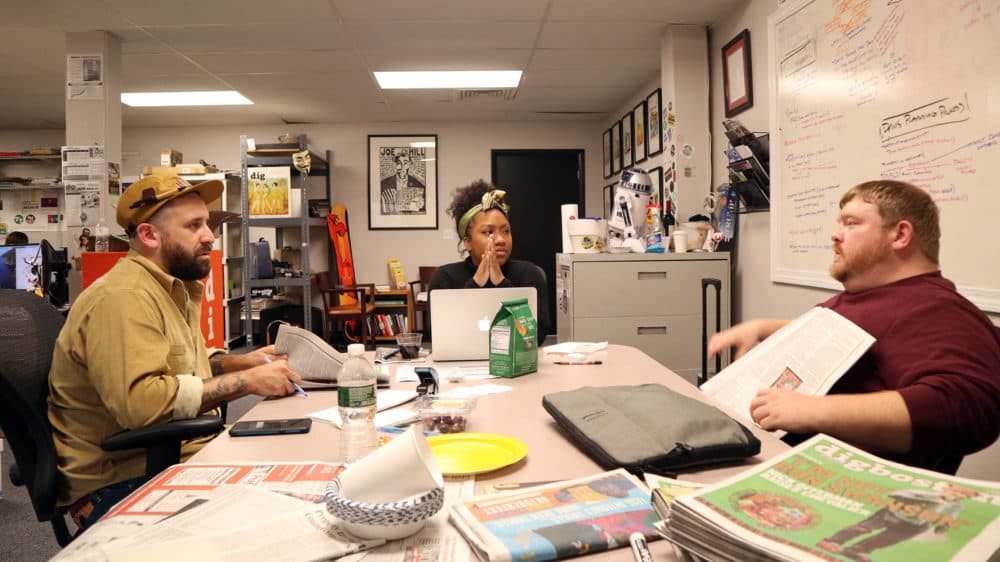 From left: Chris Faraone, editor-in-chief of DigBoston, Dawn Martin, senior account manager, and John Loftus, publisher, discuss potential advertisers for an upcoming issue. (Adrian Ma/WBUR)