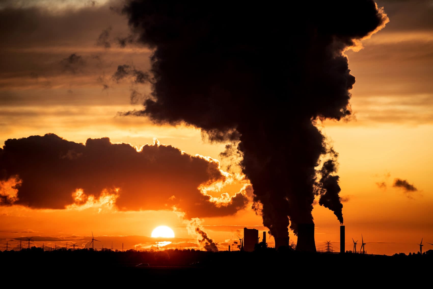 The sunset is pictured as steam rises from the chimneys of Niederaussen lignite-fired power plant in Roggendorf, western Germany on Nov. 8, 2019. (Federico Gambarini/dpa/AFP via Getty Images)