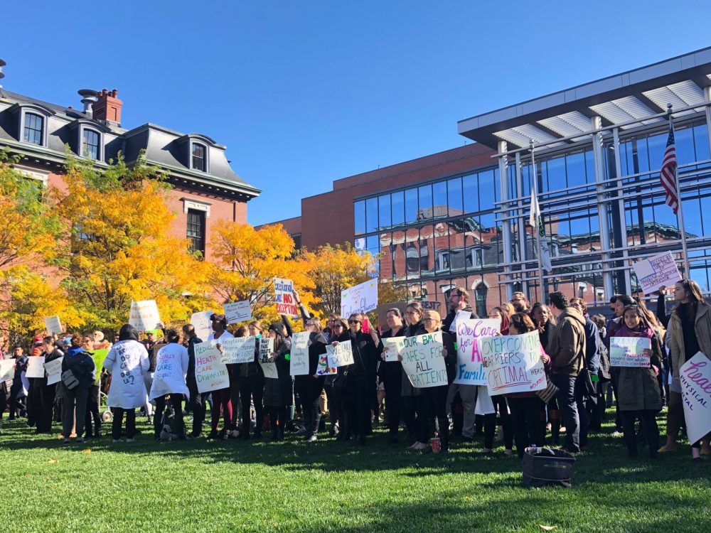 Protesters held signs outside Boston Medical Center during first lady Melania Trump's visit on Wednesday. (Shannon Dooling/WBUR)