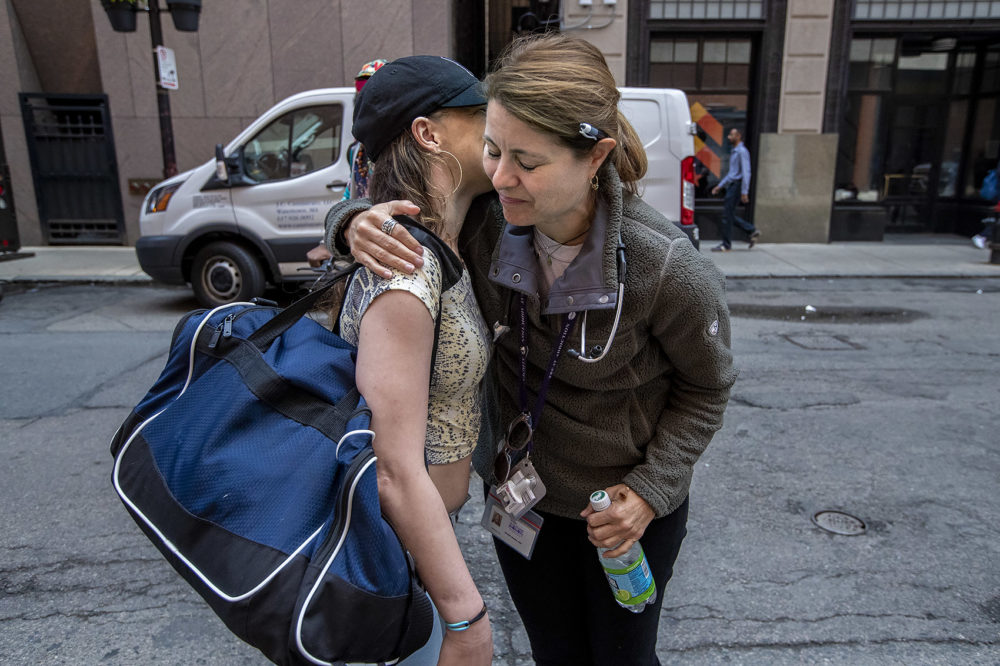 Jessie Gaeta gives Bri a hug as she heads back out onto the streets at Downtown Crossing. (Jesse Costa/WBUR)
