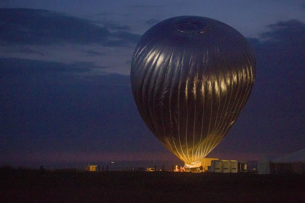 Doug Aitken's balloon fills with hot air at Long Point Wildlife Refuge on Martha's Vineyard, but soon after this moment the balloon crew, battling with the wind, decided to abandon the evening's attempt to lift the balloon's basket off the ground. (Robin Lubbock/WBUR)