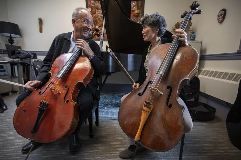 Luis Claret, cellist and New England Conservatory string department chair and Yeesun Kim, Borromeo Quartet cellist, NEC cello faculty, have a laugh after playing the Cello Suite No. 1 by Johann Sebastian Bach. (Jesse Costa/WBUR)