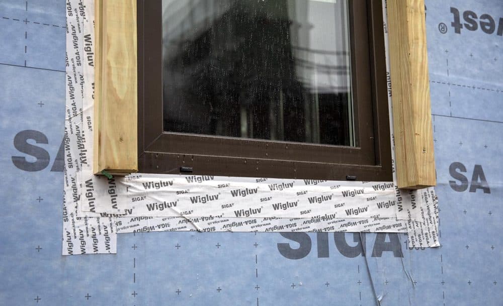Blue air barrier wrap and sealing tape around windows add to the building's airtight envelope. (Robin Lubbock/WBUR)