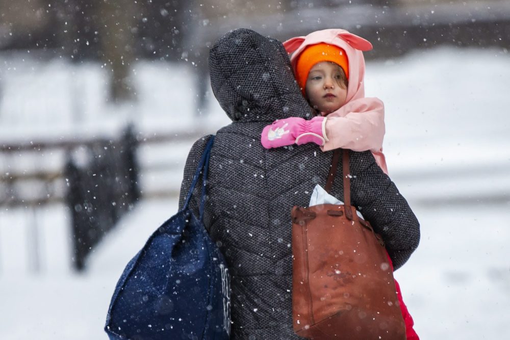 A mother and her young daughter make their way though the morning snow in Copley Square. (Jesse Costa/WBUR)