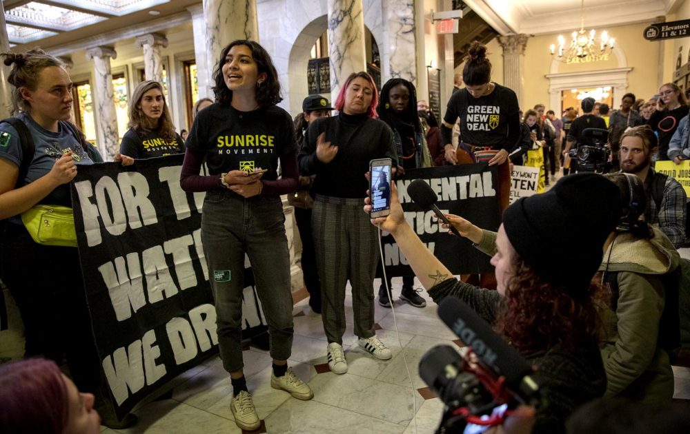 Maya Mudgal, a second-year student at Northeastern, addresses climate protesters gathered outside the Baker's office at the State House. (Robin Lubbock/WBUR)