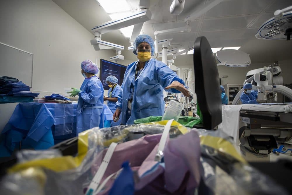 Janine Hardman recycles some paper wrapping while prepping for the next procedure in the operating room. (Jesse Costa/WBUR)