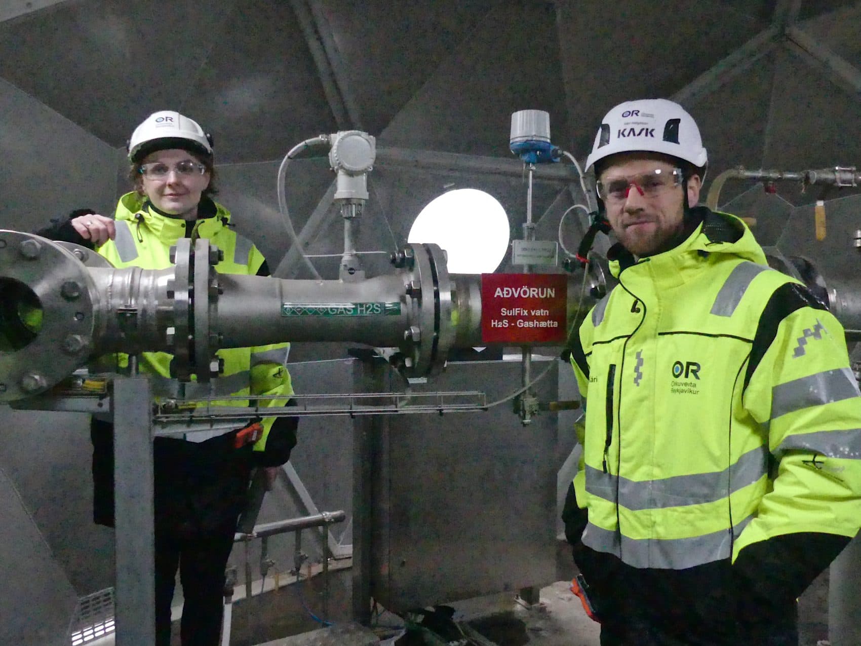 Sandra Ósk Snæbjörnsdóttir (left) and Kári Helgason at the injection well indoors. (Karyn Miller-Medzon/Here & Now)