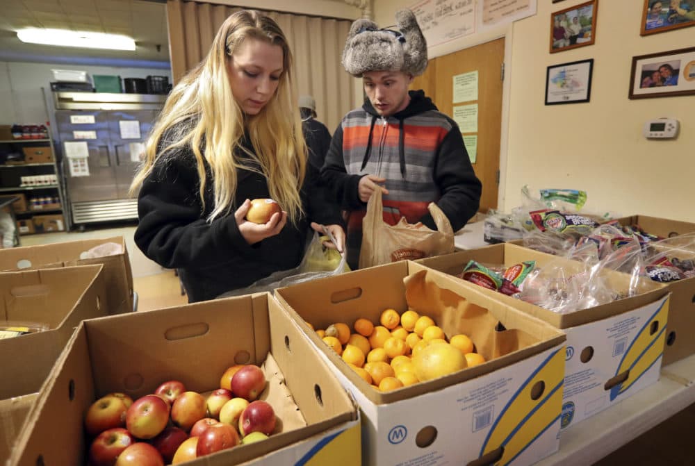 In this March 27, 2017 file photo Sunny Larson, left, and Zak McCutcheon pick produce while gathering provisions to take home at the Augusta Food Bank in Augusta, Maine. (Robert F. Bukaty/AP)
