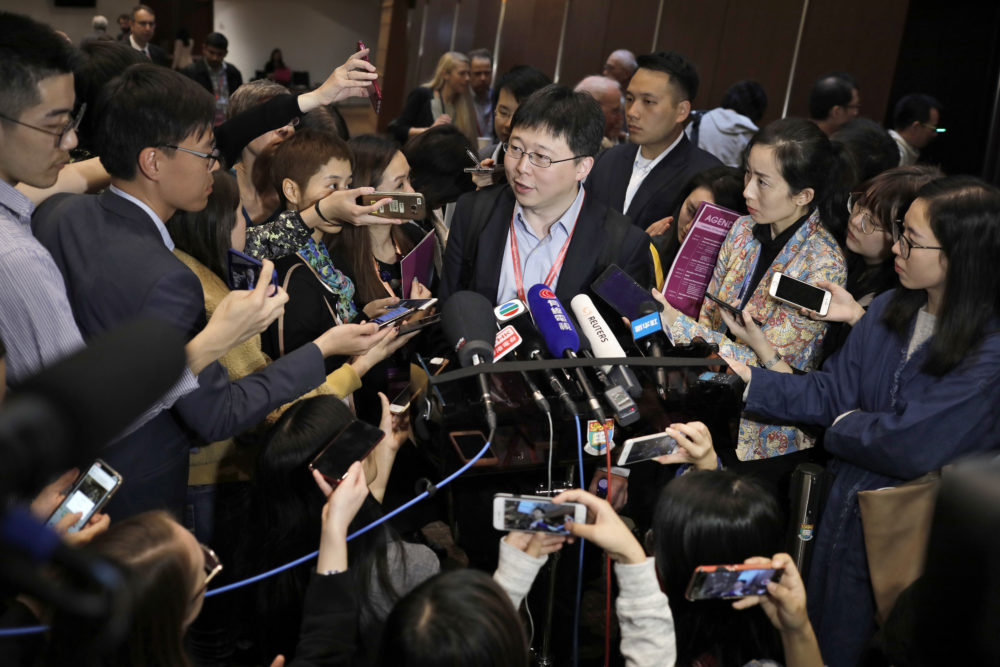 Feng Zhang, center, an institute member of Harvard and MIT's Broad Institute, is surrounded by reporters while speaking on the issue of world's first genetically edited babies after the Human Genome Editing Conference in Hong Kong, Tuesday, Nov. 27, 2018. (Vincent Yu/AP)