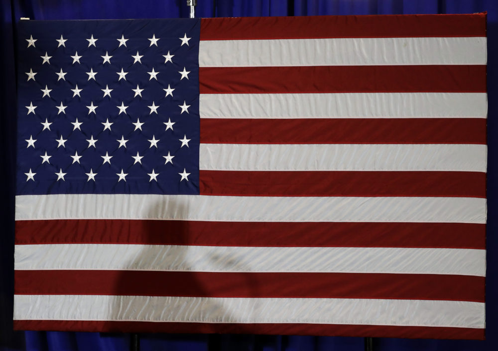 President Trump's shadow is shown on an American flag. (Chuck Burton/AP)