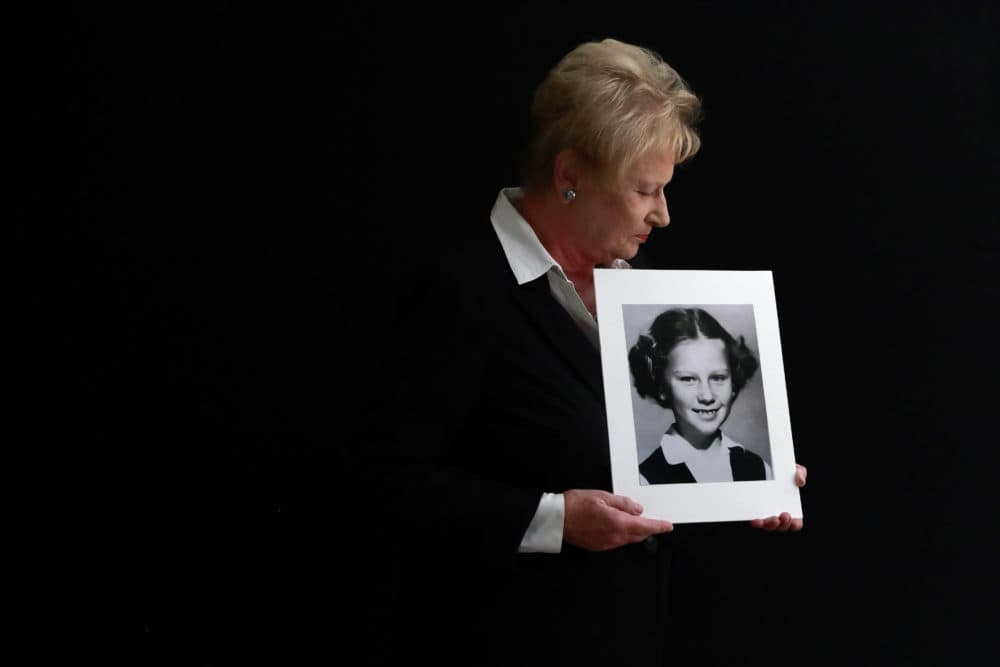 Nancy Holling-Lonnecker, 71, poses with a picture taken of her as a young girl, at her home in San Diego. Holling-Lonnecker plans to take advantage of an upcoming three-year window in California that allows people to make claims of sexual abuse no matter how old. (Gregory Bull/AP)