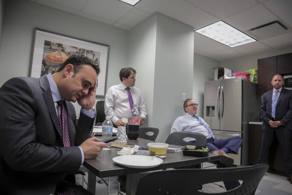 Adam Slater, left, checks his phone during a working lunch with lawyers in his firm. (Bebeto Matthews/AP)