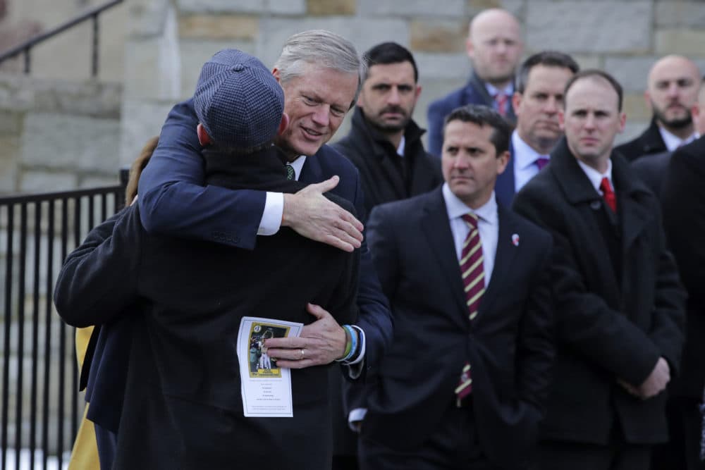 Massachusetts Gov. Charlie Baker embraces former Boston Police Commissioner William Evans while arriving for the funeral of Pete Frates at St. Ignatius of Loyola Parish church at Boston College. (Charles Krupa/AP)