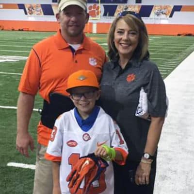 Jeremy, Brandy and Aaron Ritz poses with Hunter Renfrow's gloves. (Courtesy Aaron's Army) 