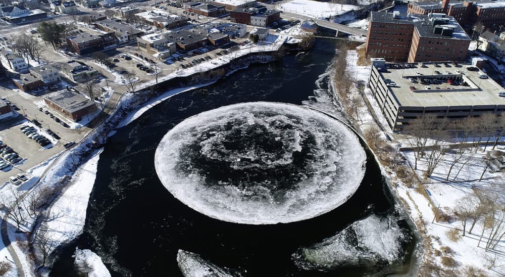 In this Monday, Jan. 14, 2019 aerial file image taken from a drone video and provided by the City of Westbrook, Maine, a naturally occurring ice disk forms on the Presumpscot River in Westbrook, Maine. The giant spinning ice disk, that quickly gained international fame and grew larger over the weekend, now has its own webcam. (Tina Radel/City of Westbrook via AP)