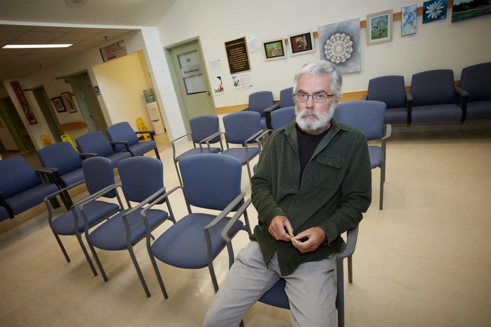 Tony Kelly sits in an empty waiting room next to the closed ER at the Annapolis Community Health Centre. (David Grandy for WBUR)
