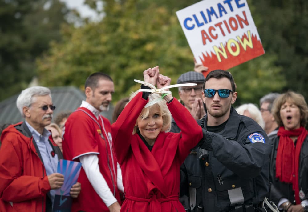 Jane Fonda is arrested at the Capitol for blocking the street after she and other demonstrators called on Congress for action to address climate change on Oct. 25, 2019. Ted Danson applauds in back at center right. (J. Scott Applewhite/AP)
