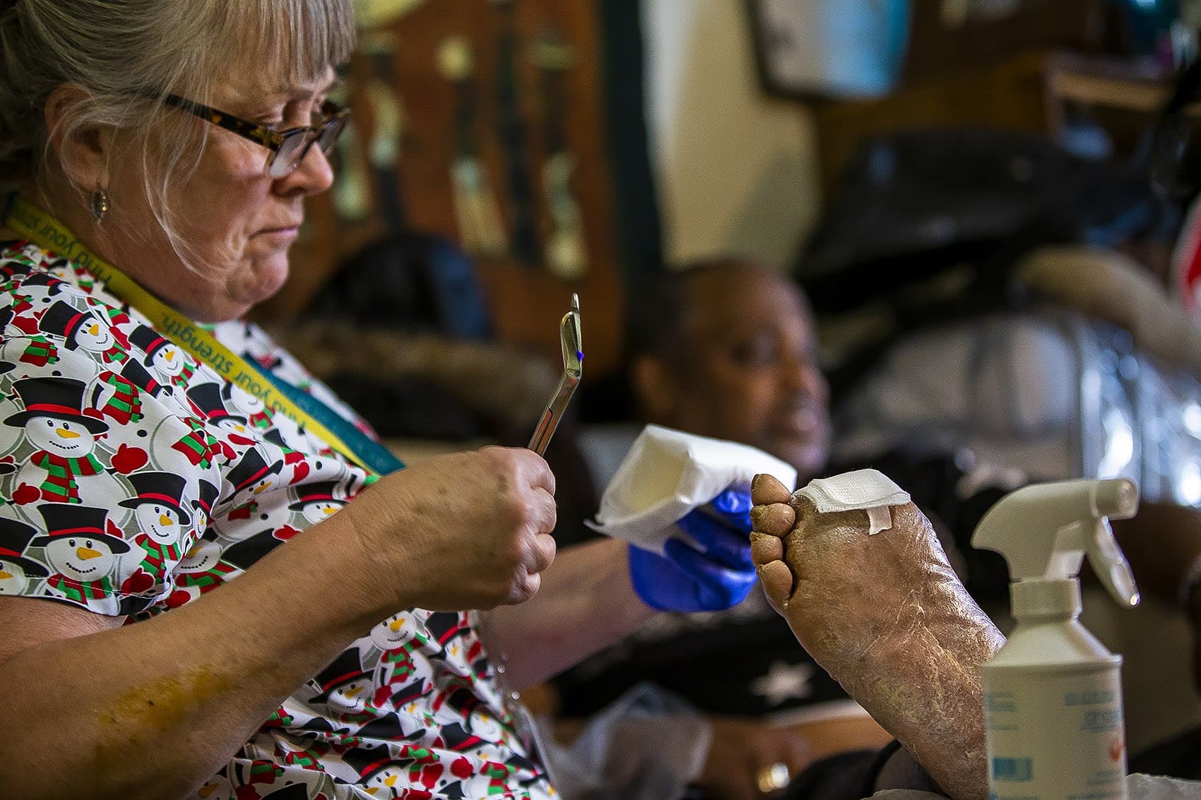 Partners visiting nurse Brenda Mastricola tends to Arthur Jackson’s foot during a visit at his home in Roxbury. His large toe has been amputated due to an infection. (Jesse Costa/WBUR)