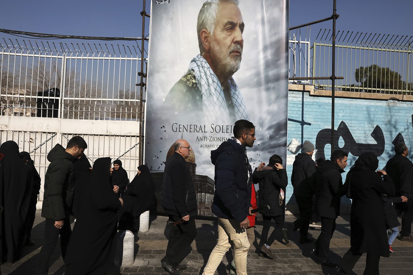 Mourners on Monday walk back from a funeral ceremony for Iranian Gen. Qassem Soleimani in front of the former U.S. Embassy, who was killed with others in Iraq by a Friday U.S. drone attack. (Vahid Salemi/AP)