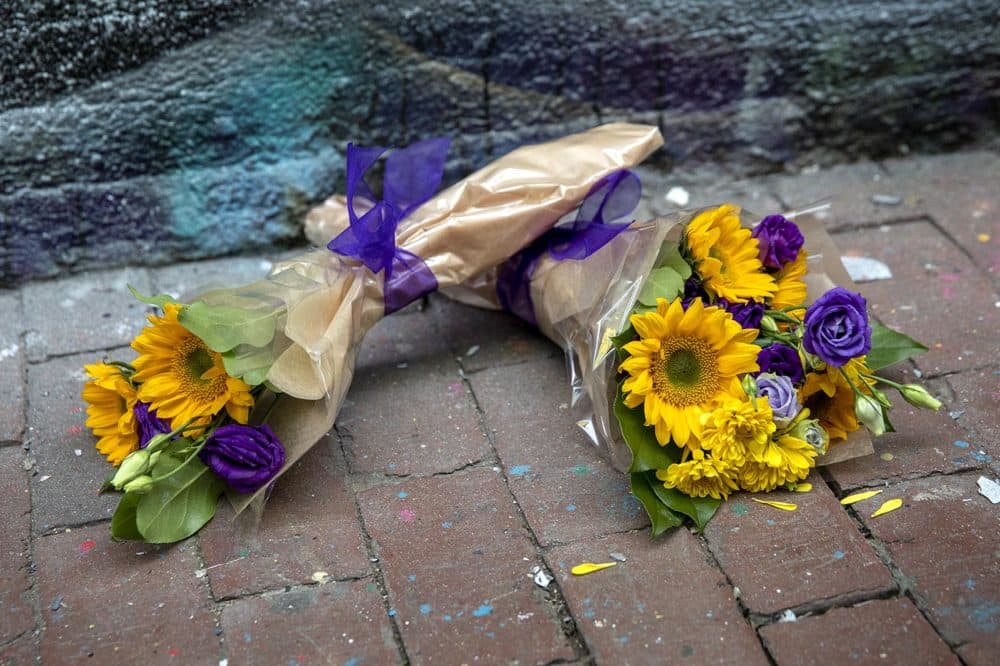 Flowers left by the mural. (Robin Lubbock/WBUR)