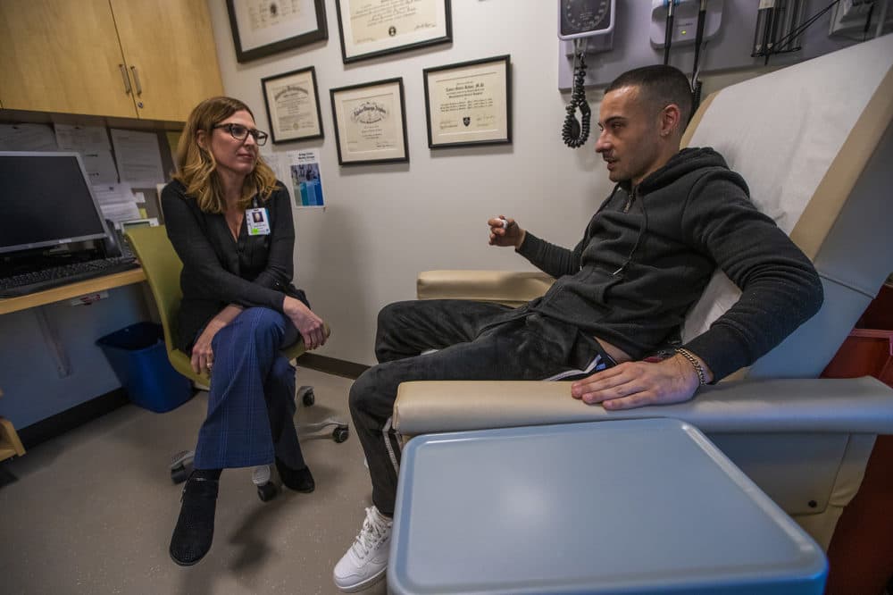 Dr. Laura Kehoe discusses with Eric how his treatment has been progressing. (Jesse Costa/WBUR)
