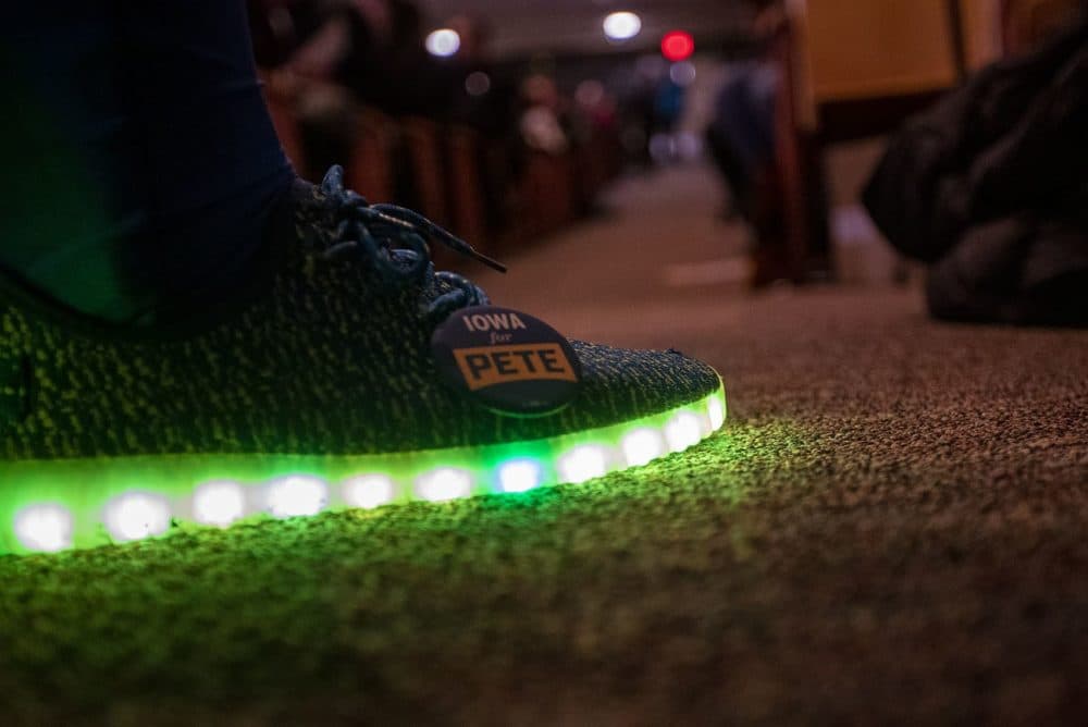 A precinct captain for Pete Buttegieg wears an “Iowa for Pete” pin on his glowing sneakers at the caucus at Central Campus High School in Des Moines. (Jesse Costa/WBUR)
