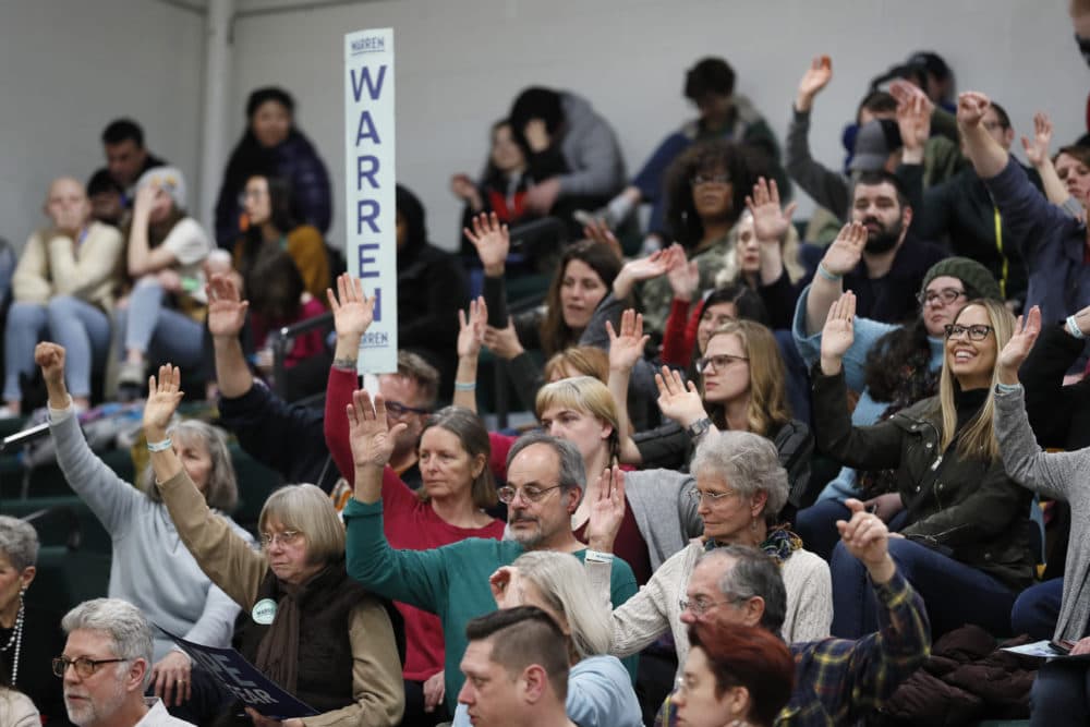 Warren supporters raise their hands to be counted during a Democratic party caucus at Hoover High School Monday in Des Moines, Iowa. (Charlie Neibergall/AP)