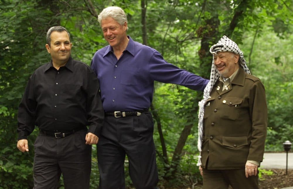 President Bill Clinton, center, accompanied by Israeli Prime Minister Ehud Barak, left, and Palestinian leader Yasser Arafat, right, walk on the grounds of Camp David, Md. in this July 11, 2000 file photo, during a Mideast summit. (Ron Edmonds/AP)