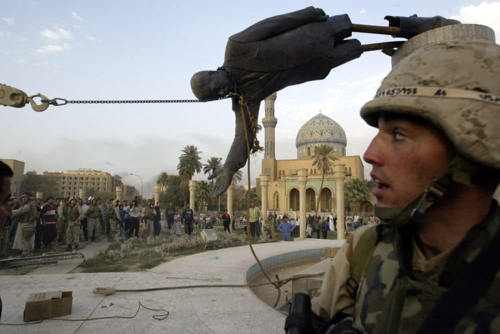 In this April 9, 2003 file photo, Iraqi civilians and U.S. soldiers pull down a statue of Saddam Hussein in downtown Baghdad, Iraq. (Jerome Delay/AP)