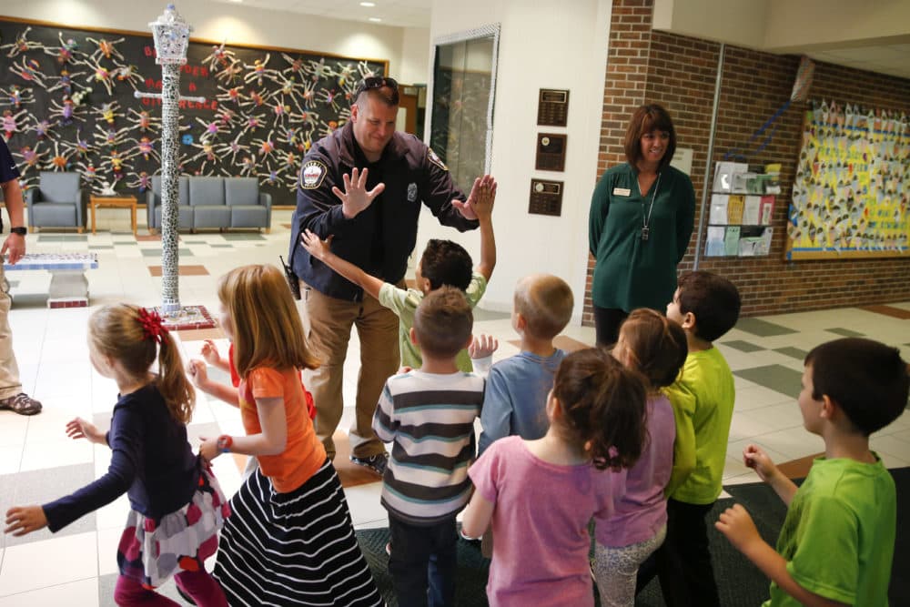 In this May 6, 2016, photo, Forest Dale Elementary School principal Deanna Pitman, right, and Carmel, (Ind.) police officer Greg DeWald welcome students as they return to the school following an intruder drill at the school in Carmel, Ind. (Michael Conroy/AP)