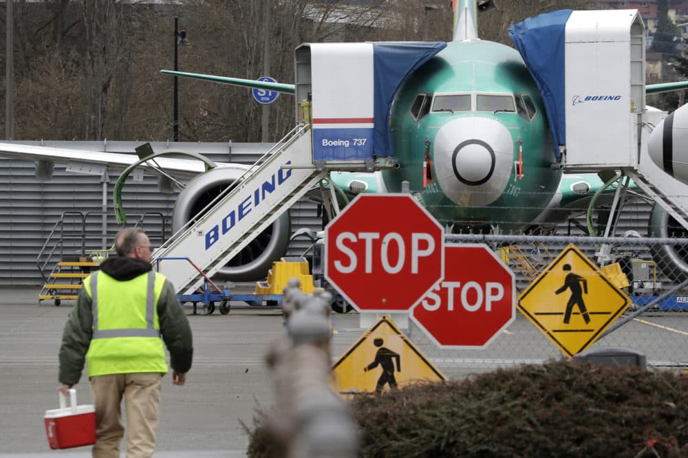 In this Monday, Dec. 16, 2019, file photo, a Boeing worker walks in view of a 737 MAX jet in Renton, Wash. (Elaine Thompson, File/AP)