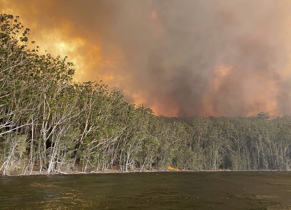 Smoke and wildfire rage behind Lake Conjola, Australia, Thursday, Jan. 2, 2020. (Robert Oerlemans via AP)