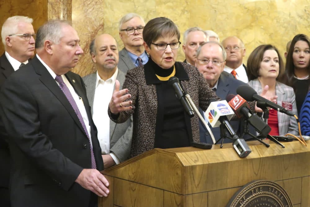 Kansas Gov. Laura Kelly, center, answers questions from reporters about a new Medicaid expansion plan as lawmakers and other advocates watch during a news conference in Topeka, Kansas. (John Hanna/AP)