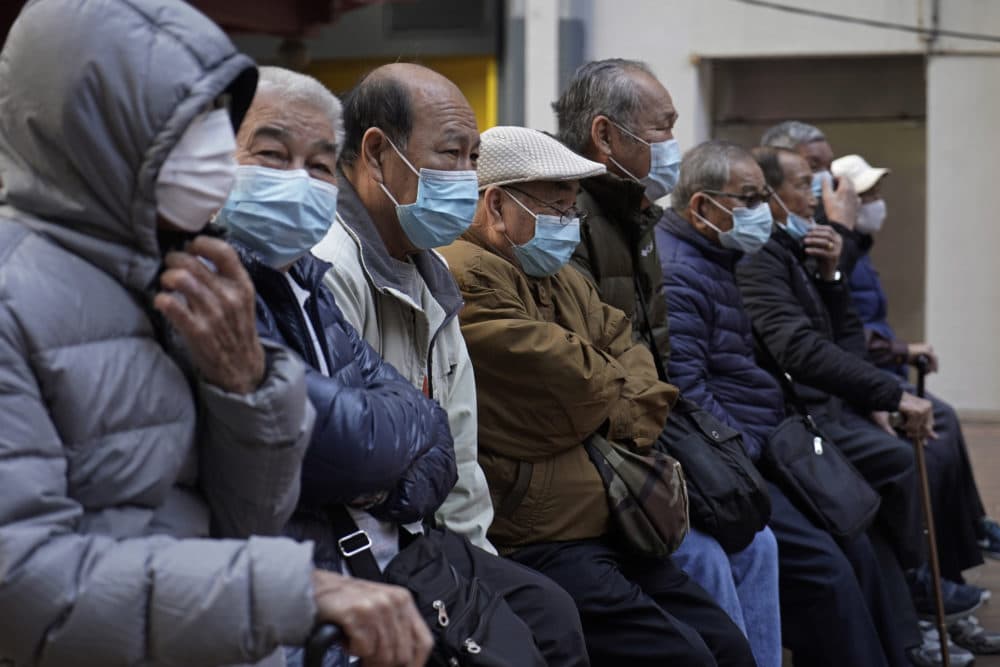 Elderly men sit at a park wearing face masks in Hong Kong, Thursday, Jan. 30, 2020. (Kin Cheung/AP)