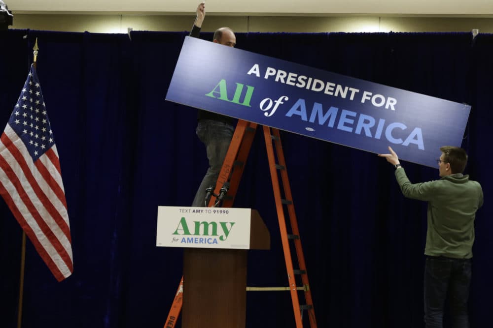Staff members hang a sign before a caucus night party for Democratic presidential candidate Amy Klobuchar, D-Minn., in Des Moines, Iowa on Monday. (Nati Harnik/AP)
